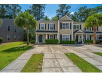 Charming two-story townhome showcasing manicured landscaping and a paved driveway at 9098 Maple Grove Dr, Summerville, SC 29485