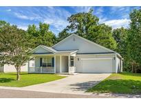 Charming single-story home featuring a two-car garage, welcoming porch, and well-manicured lawn at 1026 Briar Rose Ln, Ladson, SC 29456