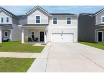 Charming two-story home featuring white siding, a well-manicured lawn, and an attached two-car garage at 112 Whisper Dr, Summerville, SC 29485
