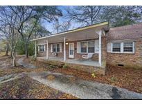 Inviting brick home featuring a quaint front porch with swing, perfect for relaxing outdoors at 1263 N Highway 52, Moncks Corner, SC 29461