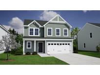 Charming two-story home with green siding, white trim, a two-car garage, and a well-manicured lawn at 165 Casein St, Summerville, SC 29483