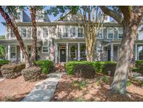 Charming townhome featuring a landscaped front yard, inviting entrance, and American flag at 1852 Pierce St, Charleston, SC 29492