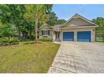 Charming single-story home featuring a two-car garage, driveway and well-manicured lawn with palm tree at 1918 Piper Dr, Charleston, SC 29407