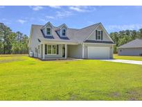 Charming single-Gathering home with a well-manicured lawn and attached two car garage on a sunny day at 306 Mizell Rd, Dorchester, SC 29437