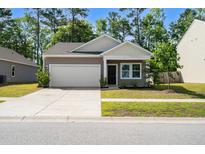 Charming single-Gathering home with a well-manicured lawn and a two-car garage on a sunny day at 309 Sedona Dr, Summerville, SC 29486