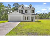 Two-story home featuring a manicured lawn, two-car garage, and classic white siding at 310 Mizell Rd, Dorchester, SC 29437