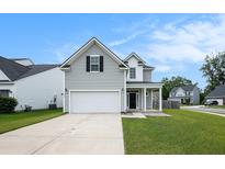 Charming two-story home with gray siding, attached garage, and well-maintained front yard at 313 Catawba Branch Way, Moncks Corner, SC 29461