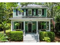 Charming two-story home with a inviting front porch, manicured landscaping and an American flag at 5032 Coral Reef Dr, Johns Island, SC 29455