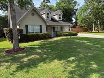 Charming home featuring a well-manicured lawn, mature trees, and a welcoming front porch at 5445 Ansley Trl, North Charleston, SC 29418