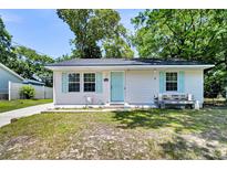 Charming single-story home featuring a light blue front door, matching shutters, and a cozy bench at 5806 Robinhood Dr, Hanahan, SC 29410