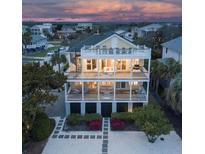 Three-story beach house featuring multiple balconies and a spiral staircase with lush landscaping at 601 Ocean Blvd, Isle of Palms, SC 29451