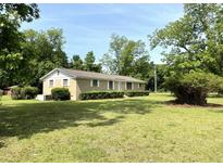 Charming single-story home with a brick facade, lush lawn, and mature trees at 6287 Sniders Hwy, Walterboro, SC 29488