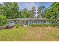 Charming single-story home features a lush front yard with beautiful landscaping and an attached garage at 803 Burnett Dr, Charleston, SC 29412