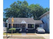 Charming single-story home with black and white trim, a covered porch, and a driveway with parking at 932 Rutledge Ave, Charleston, SC 29403