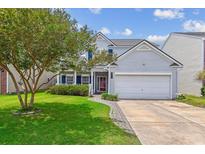 Charming two-story home with a manicured lawn, tree, driveway, and attached two-car garage at 1007 Whitlow Blvd, Summerville, SC 29483