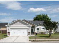 Charming single-story home with a two-car garage, attractive landscaping, and a well-maintained lawn at 115 Hyrne Dr, Goose Creek, SC 29445