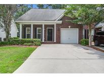 Charming brick home featuring a well-manicured lawn, single-car garage, and inviting front porch with white columns at 116 Venezia Ct, Ladson, SC 29456