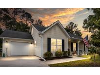 Charming single-story home with an attached garage and manicured lawn at sunset at 1583 Southwick Dr, Johns Island, SC 29455