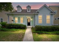 Charming one-story home featuring a covered front porch, dormer windows, and mature landscaping at 1870 Gammon St, Charleston, SC 29414