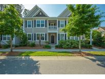 Inviting townhome with neutral siding, black shutters, and a charming front porch at 1876 Towne St, Johns Island, SC 29455