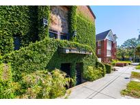Unique brick building exterior covered in lush green ivy on a sunny day at 2 Francis St # I, Charleston, SC 29403