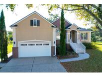 Charming stucco and brick home featuring a two-car garage and inviting front entrance at 2206 Magnolia Meadows Dr, Mount Pleasant, SC 29464