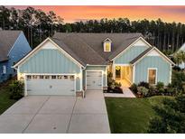 Beautiful home showcasing an expansive driveway and three-car garage, complemented by a lush green lawn at 467 Hidden Meadow Ln, Summerville, SC 29486