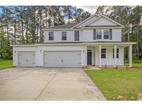 New two-story home boasts white siding, dark shutters, and a spacious three-car garage in a wooded area at 5182 Stono Plantation Rd Dr, Hollywood, SC 29449