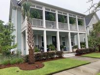 Charming two-story home with a spacious porch, well-manicured lawn and beautiful landscaping at 525 Scholar Way, Summerville, SC 29486