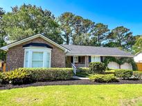 Charming brick home with manicured landscaping, a welcoming front porch, and an attached two-car garage at 946 Law Ln, Mount Pleasant, SC 29464