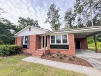 Charming brick home with well-maintained lawn and attached carport offers classic appeal at 105 Dandridge Rd, Walterboro, SC 29488