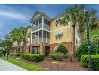 Exterior view of a multi-story building featuring yellow siding and brick accents and screened in porches at 1319 Basildon Rd, Mount Pleasant, SC 29466