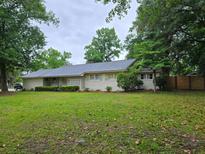 Charming single-story home featuring a landscaped yard, neutral paint, and a serene, tree-lined street at 1350 Mosstree Rd, North Charleston, SC 29405