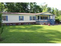 Charming single-story home with a welcoming porch and a spacious, well-maintained front yard at 204 Pete Ewers Dr, Summerville, SC 29483