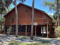 Charming raised home with wood siding, decks, and lush landscaping at 209 Jungle Rd, Edisto Beach, SC 29438