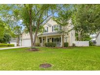 Inviting two-story home featuring a well-manicured lawn and mature trees creating a warm curb appeal at 261 Mossy Oak Way, Mount Pleasant, SC 29464