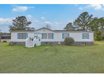 Inviting single-story home featuring blue shutters, a well-manicured lawn, and ample parking at 307 Glen St, Summerville, SC 29483