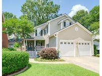Charming two-story home featuring a manicured lawn and a two-car garage at 332 Clayton Dr, Charleston, SC 29414