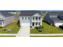 Charming two-story home featuring a light blue facade, a second story balcony, and a well manicured lawn at 447 Navona Dr, Summerville, SC 29486