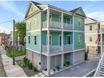 Charming three-story home with lovely pale-green siding and double-decker porches and white railings at 48 Aiken St, Charleston, SC 29403