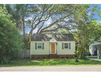 Charming single-story home featuring a well-manicured lawn, mature trees, and a classic architectural design with shutters on the windows at 4810 Parkside Dr, North Charleston, SC 29405
