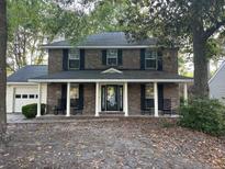 Charming two-story brick home with black shutters, rocking chairs, and a covered front porch at 529 Laurel Ridge Rd, North Charleston, SC 29418