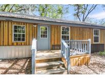 Charming home featuring wood siding, a metal roof, and a welcoming entryway with light blue trim at 5375 Highway 174, Adams Run, SC 29426