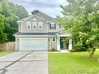 Charming two-story home boasts a well-manicured lawn and attached two car garage at 610 Knowledge Dr, Ladson, SC 29456