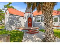 Charming home with a unique turret entrance, red door, orange roof, gray brick, and mature palm tree at 7 Wesley Dr, Charleston, SC 29407