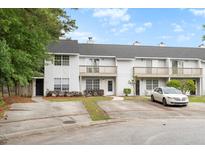 View of townhomes featuring balconies, trimmed bushes, and individual parking spots at 7813 Sandida Ct, North Charleston, SC 29418