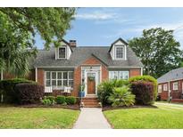 Charming brick home with dormer windows, lush landscaping, and a welcoming front porch at 95 Gordon St, Charleston, SC 29403
