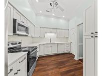 Well-lit kitchen featuring white cabinetry, stainless steel appliances, and dark hardwood floors at 108 Woodlake Dr, Summerville, SC 29485