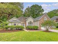 Charming home featuring a manicured lawn, lush landscaping, and a blend of brick and siding on the exterior at 1148 Black Rush Cir, Mount Pleasant, SC 29466