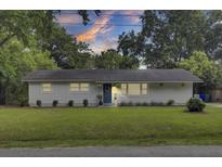 Charming single-story home featuring a landscaped lawn, a welcoming front door with a wreath, and light gray siding at 1515 Mulberry St, Charleston, SC 29407